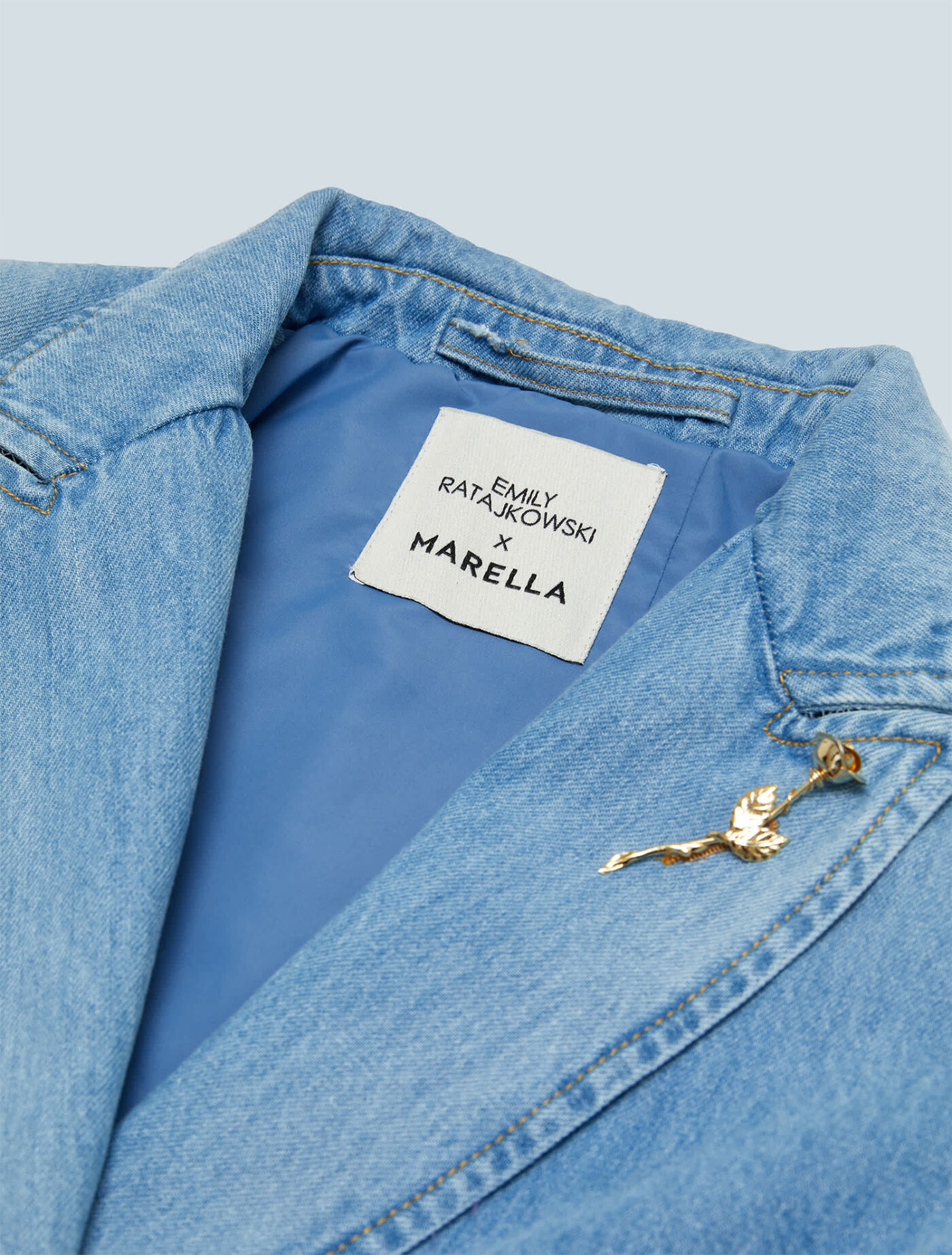 Besondere Details ist die abnehmbare Brosche in Form einer Rose, die die Weiblichkeit symbolisiert und häufig das Markenzeichen von Marella darstellt.