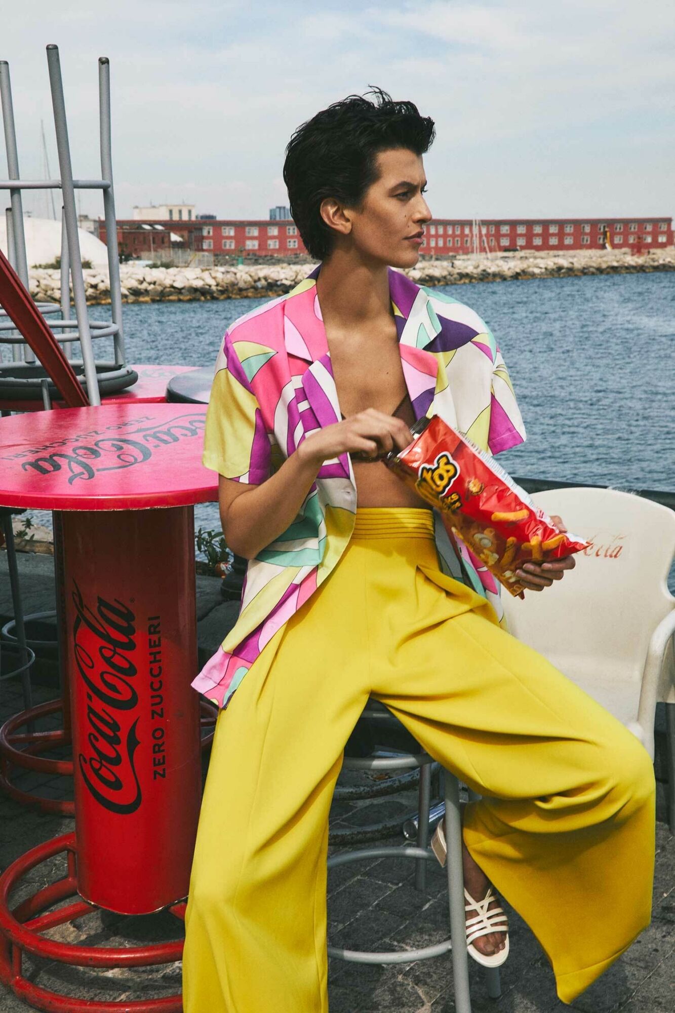 Sonnengelbe Hose, von Marc Cain, um 230 Euro. Bikini-Oberteil mit Hemdbluse im Miami-Stil darüber, von Love Stories, um 90 und 140 Euro. Sandalen: Chanel (Foto: Adriano Russo)